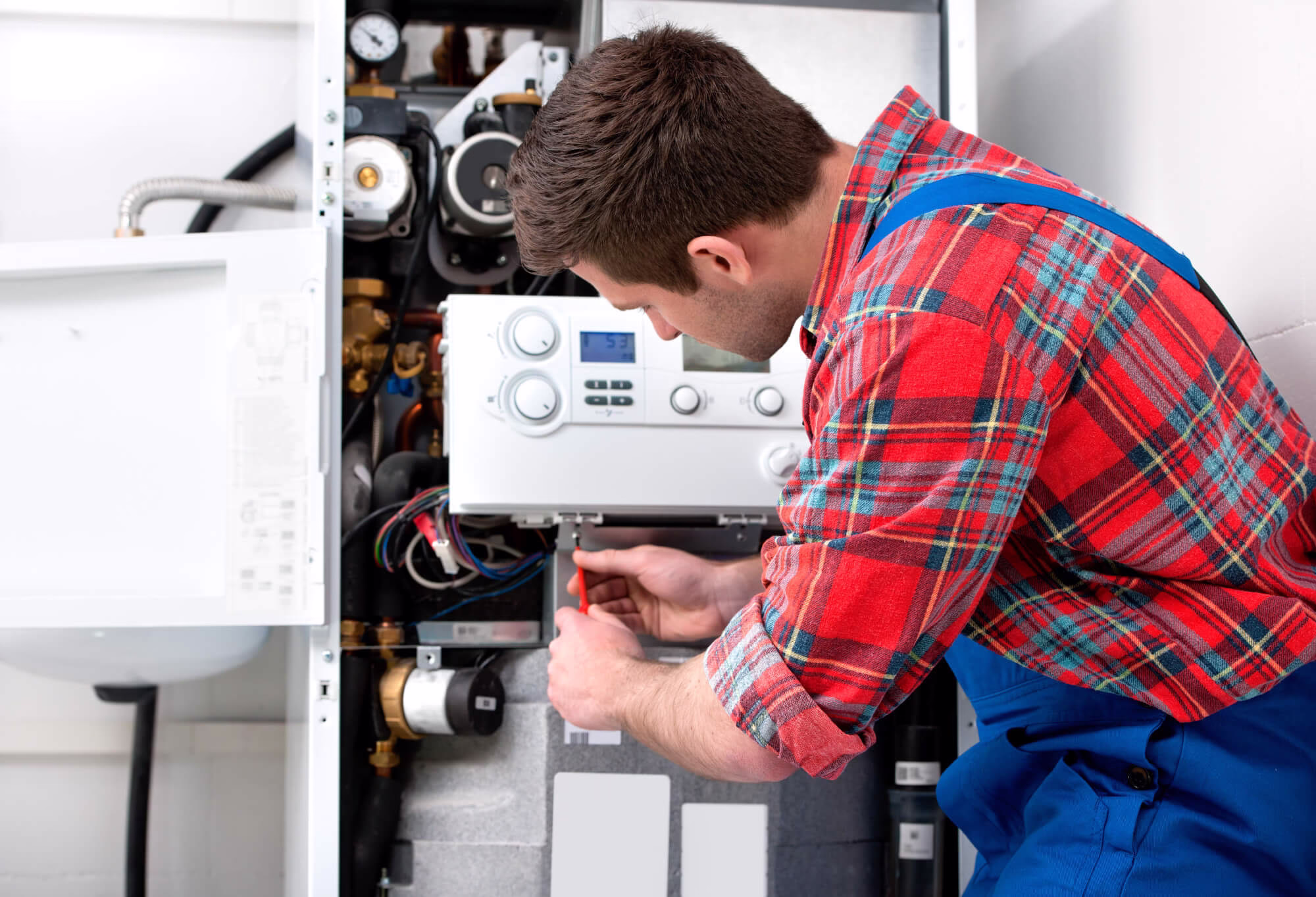 A plumber is repairing the boiler in Queens, NY